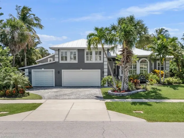View of front of home featuring stucco siding, decorative driveway, a front yard, and an attached garage