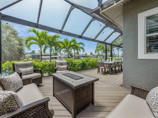 Wooden terrace featuring outdoor dining area, an outdoor hangout area, and a lanai