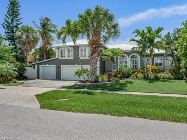 View of front of house with stucco siding, a garage, driveway, and a front yard