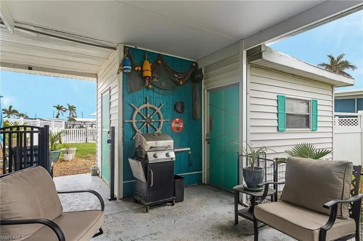 Patio under the carport with storage and laundry sheds.