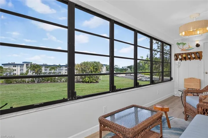 Lanai featuring a full wall of multi-pane windows and light-toned wood-finish flooring