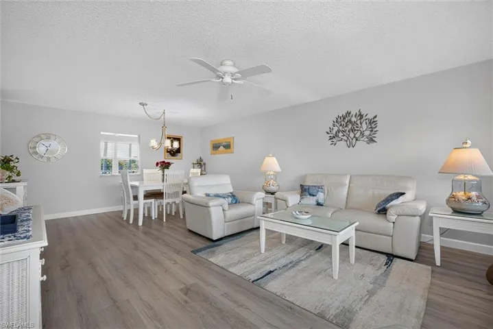 Open-concept living and dining area featuring wood-finish flooring, a ceiling fan, and recessed lighting