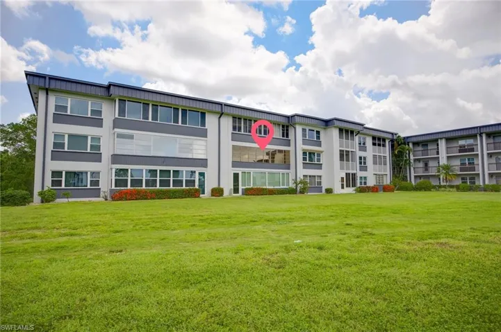 Low-rise multi-family building featuring a light gray and dark gray facade with multiple window styles