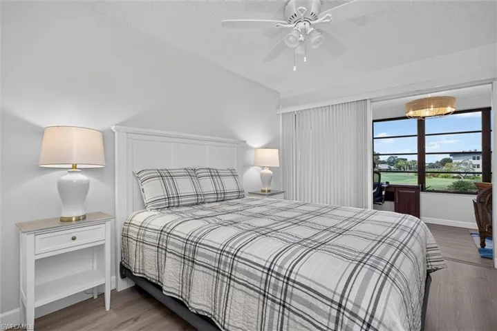 Guest Bedroom Bright interior space featuring a white paneled headboard, light wood-finish flooring, and a ceiling fan with integrated lighting