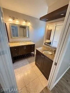 Bathroom with two vanities and light tile patterned floors