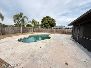 View of swimming pool with a fenced backyard, a sunroom, and patio surround