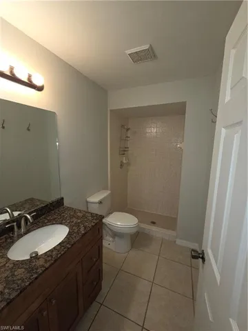 Bathroom with a shower stall, vanity, and light tile patterned floors