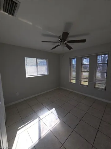 Unfurnished room with light tile patterned floors and a ceiling fan