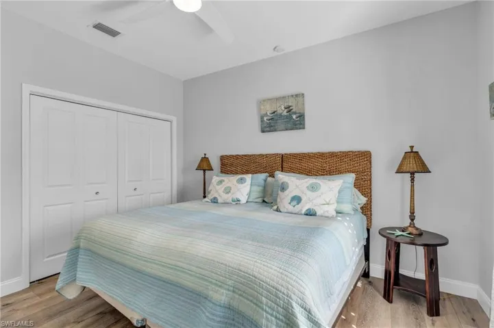Bedroom with light wood-look flooring, a closet, and ceiling fan