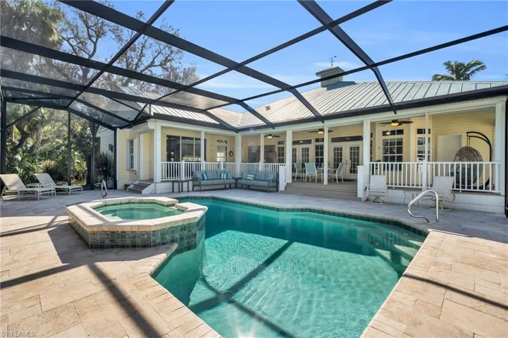 View of swimming pool with an in ground spa , ceiling fan, a screened lanai, and a patio area
