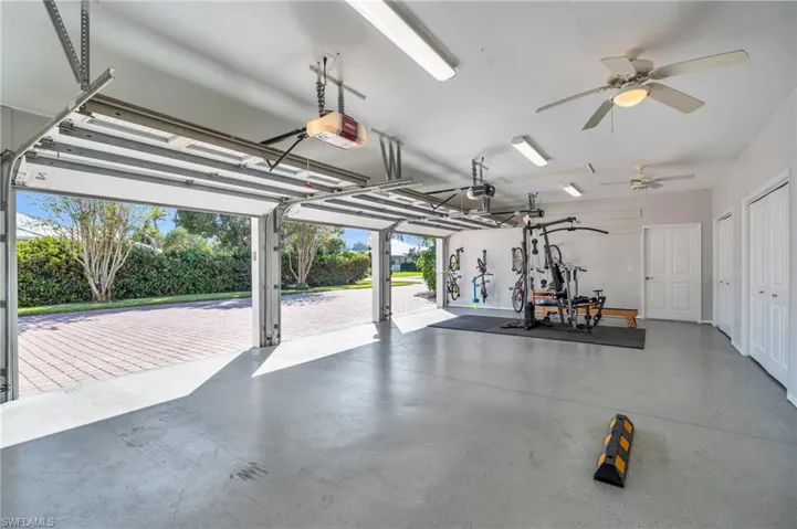 4 Car Garage featuring 3 car bay with a 4th bay Shop with a garage door opener and ceiling fan