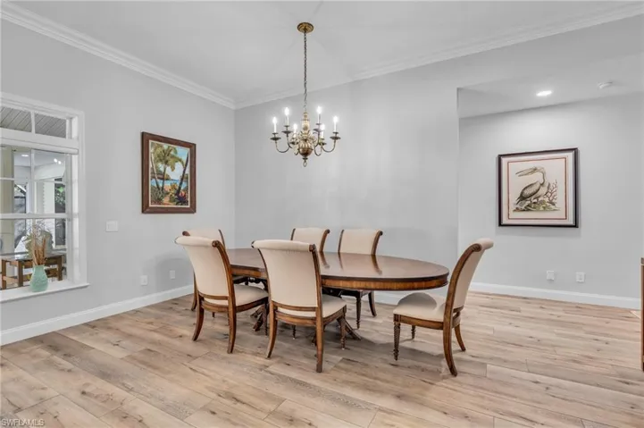 Dining area featuring an inviting chandelier, crown molding, and light wood-Look flooring