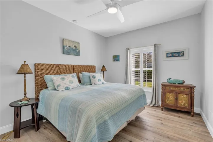 Bedroom with light wood-look  floors and ceiling fan King Bed/2 twins