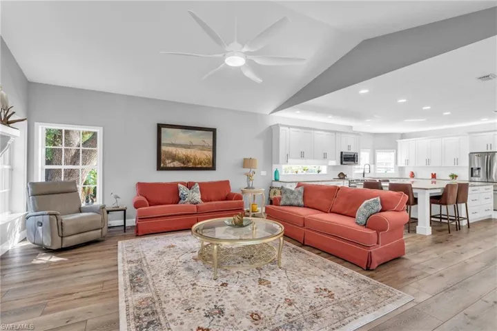 Living room featuring , vaulted ceiling, light / wood-Look flooring, and ceiling fan