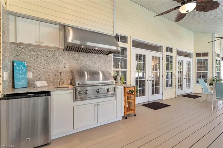 Deck featuring an outdoor kitchen, ceiling fan, french doors, sink, and a grill