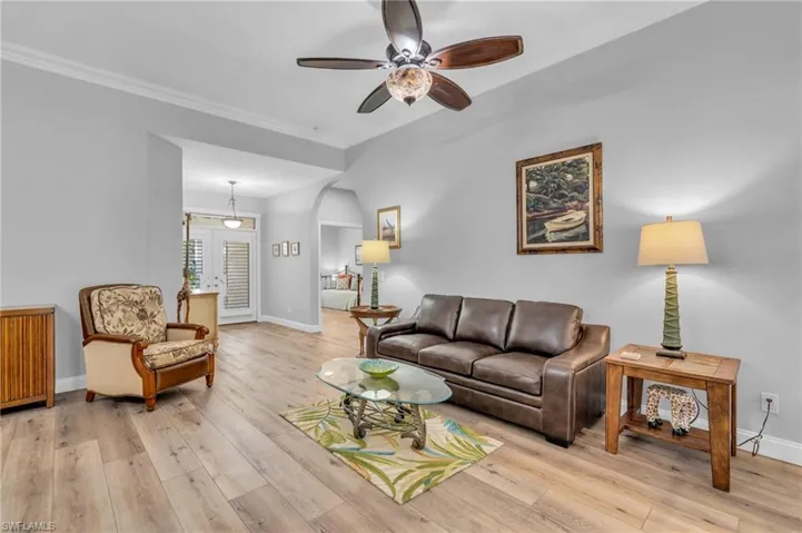 Living room with crown molding and light wood-look flooring