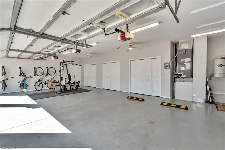 4  CarGarage featuring 3 car Bay and 4th Bay Shop  ceiling fan, a garage door opener, heating unit, and water heater