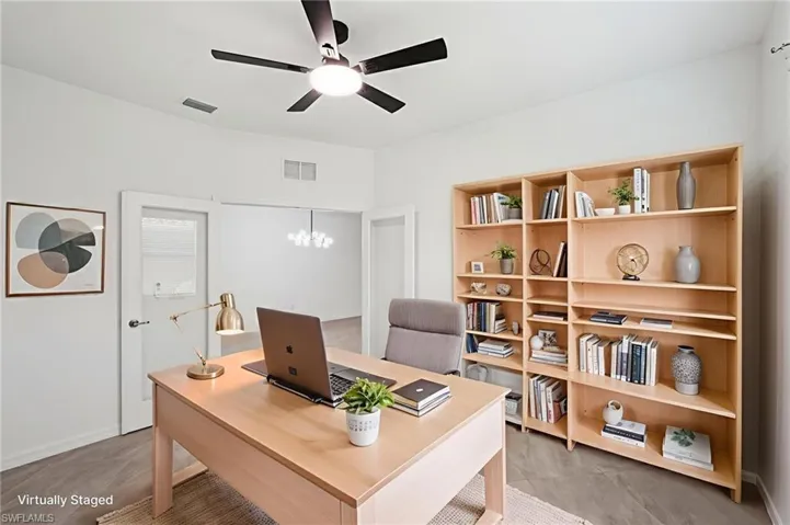Den featuring ceiling fan and baseboards