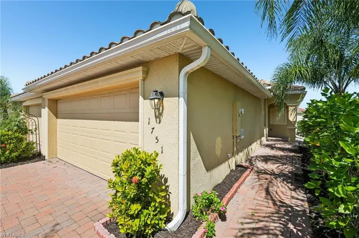 View of side of home featuring stucco siding, an attached garage, and driveway