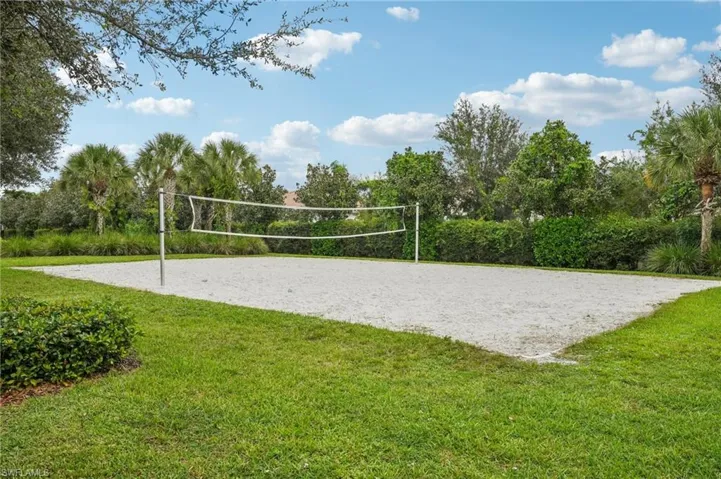 View of property's community featuring volleyball court and a lawn
