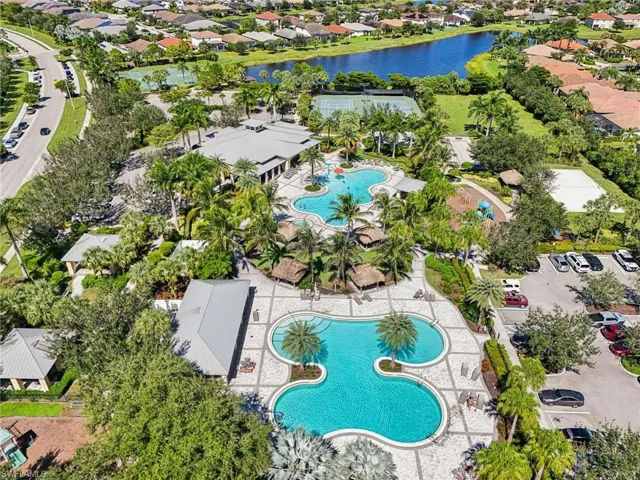 Aerial view of residential area featuring a pool area and a large body of water
