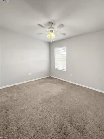 Empty room with carpet and ceiling fan