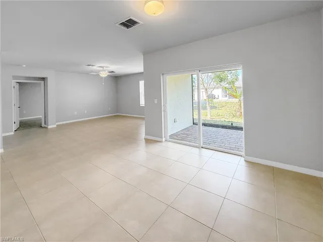 Empty room featuring light tile patterned floors and ceiling fan