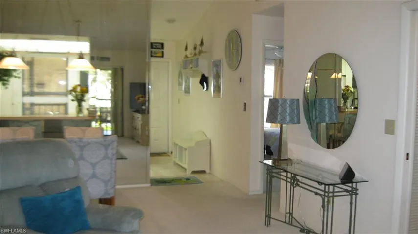 View of carpeted living/dining area and entry hallway.