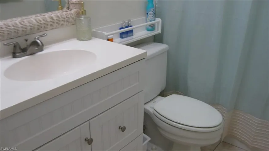 Bathroom with a shower with curtain, vanity, and toilet