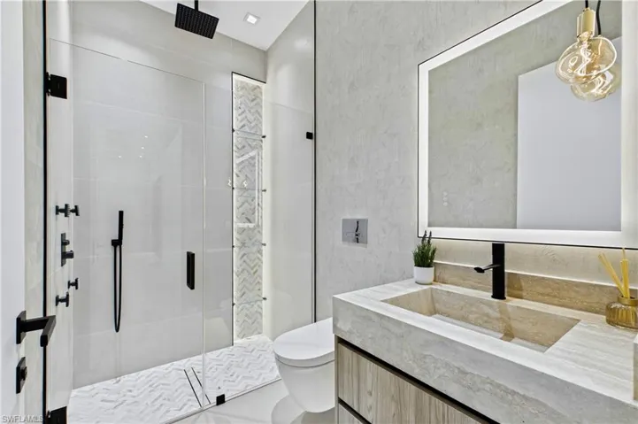3rd Guest Bathroom - Elegant guest bathroom featuring a frameless glass shower, integrated stone vanity, designer lighting, and upscale contemporary finishes