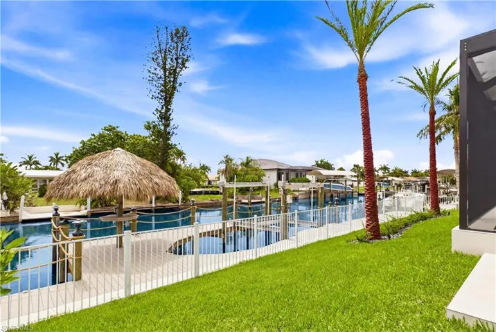 The waterfront amenities are designed for serious boaters, featuring a fully equipped dock with captain’s walk, 10,000-lb boat lift, water, electric, and ambient lighting