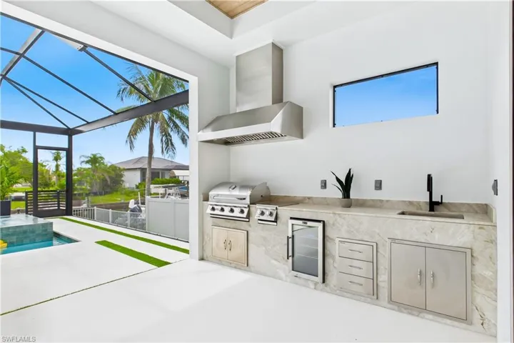 OUTDOOR KITCHEN w/ Bull grill, side burner, hood, fridge, sink & storage