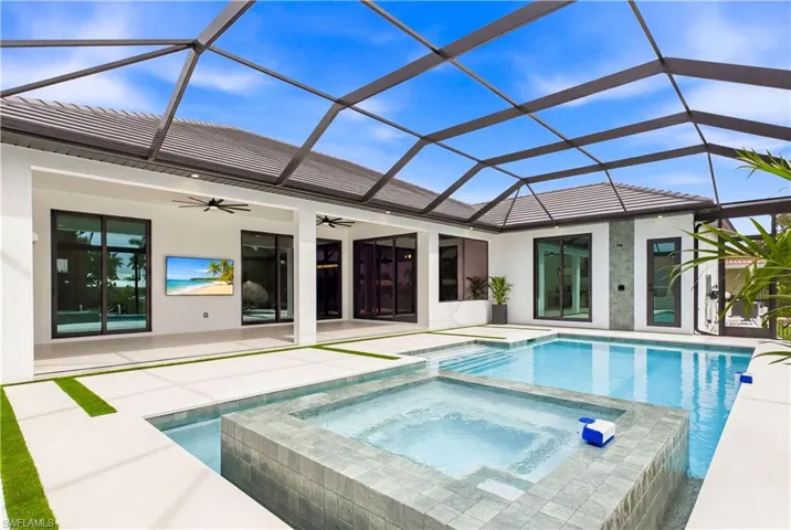 Elevated spa with spillover feature serves as the centerpiece of the resort-style pool, creating a luxurious setting for relaxation!