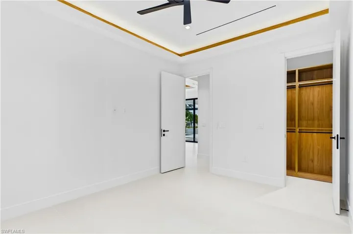 3rd Guest Bedroom - Private guest suite featuring a tray ceiling with ambient lighting, custom walk-in closet, and a bright, airy design that offers both comfort and style for family or visitors