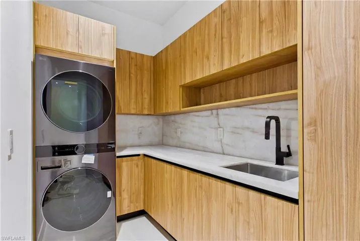 Laundry room w/ LG washer & dryer, utility sink w/ full backsplash, L-shaped countertop & ample STORAGE