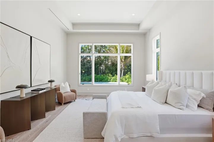 This well-lit room features light-toned walls, recessed lighting, and a tray ceiling