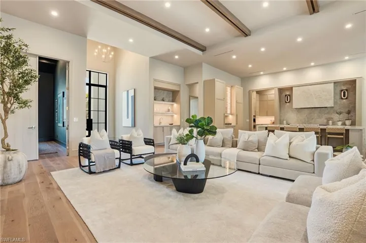 Open-concept living area with high ceilings, recessed lighting, and wood-finish flooring
