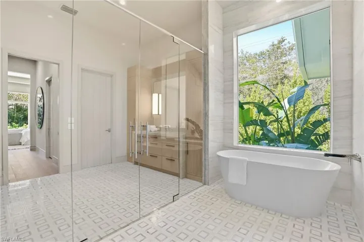 Full bathroom featuring plenty of natural light, a soaking tub, connected bathroom, and a shower stall