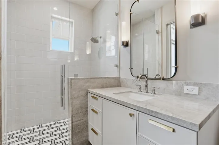 Full bath with vanity, a shower stall, and tile walls