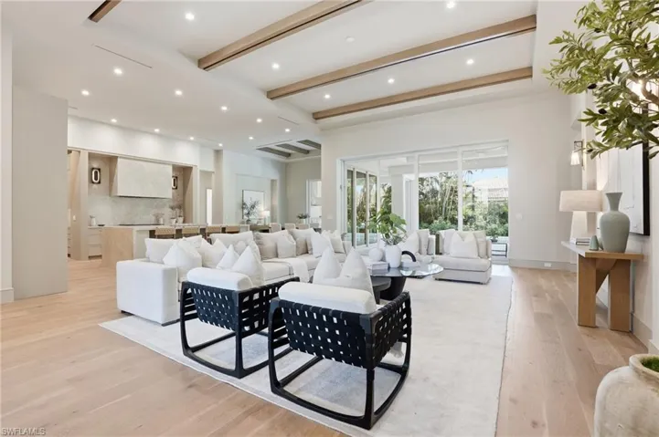 Living room featuring beam ceiling, recessed lighting, and light wood-style flooring