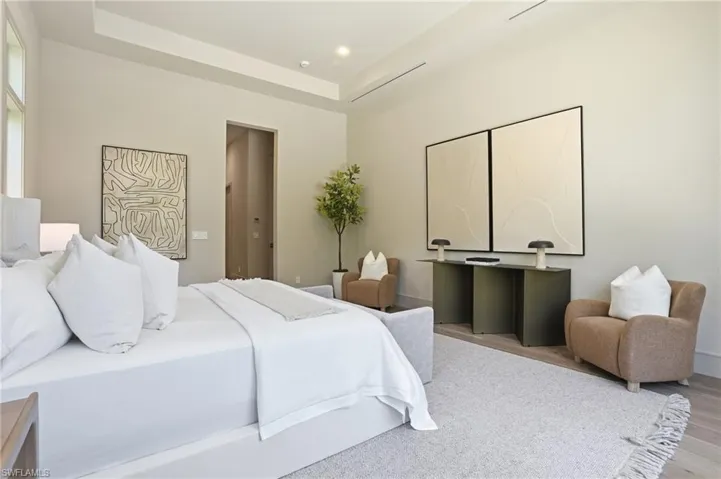 Bedroom featuring a tray ceiling and wood finished floors