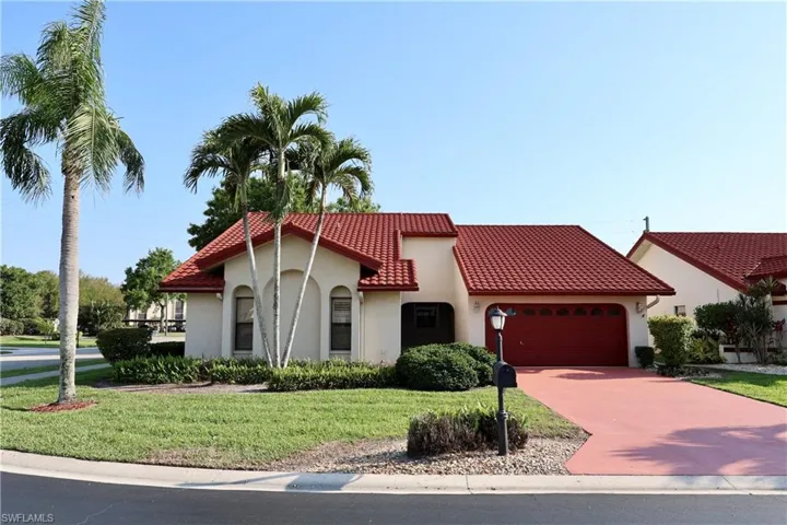 Mediterranean / spanish-style house with a garage, stucco siding, concrete driveway, a front lawn, and a tile roof