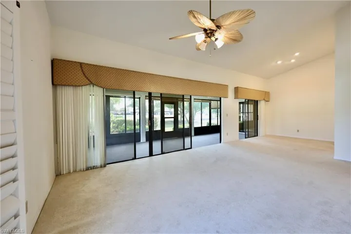 Spare room featuring light colored carpet, a ceiling fan, vaulted ceiling, and recessed lighting
