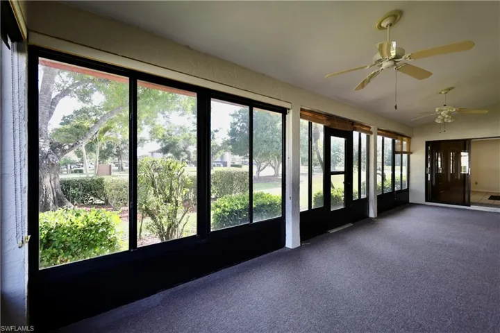 Unfurnished sunroom featuring ceiling fan and carpet flooring