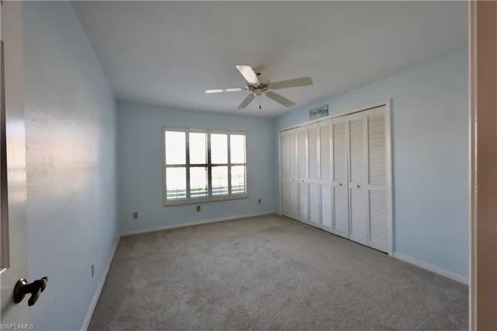 Unfurnished bedroom featuring carpet floors, a closet, and a ceiling fan