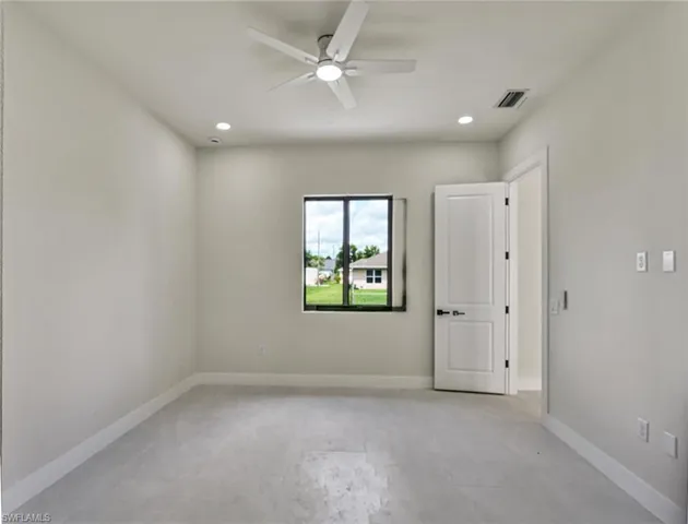 Spacious room featuring light-toned flooring, recessed lighting, and a contemporary ceiling fan