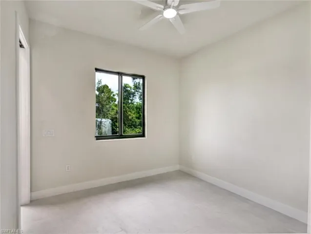 Bright room featuring a window with dark framing, a ceiling fan, light-colored walls, and tile flooring