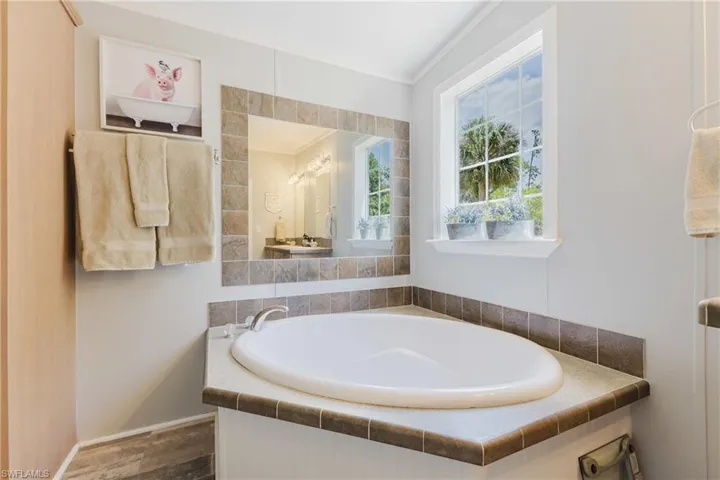 Bathroom with a garden tub and wood finished floors