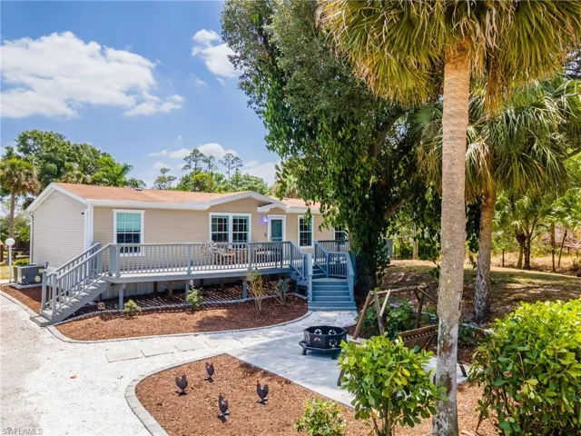 View of front facade featuring a deck, a patio, a fire pit, and central AC unit