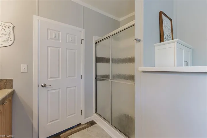 Full bathroom featuring crown molding, an enclosed shower, and vanity